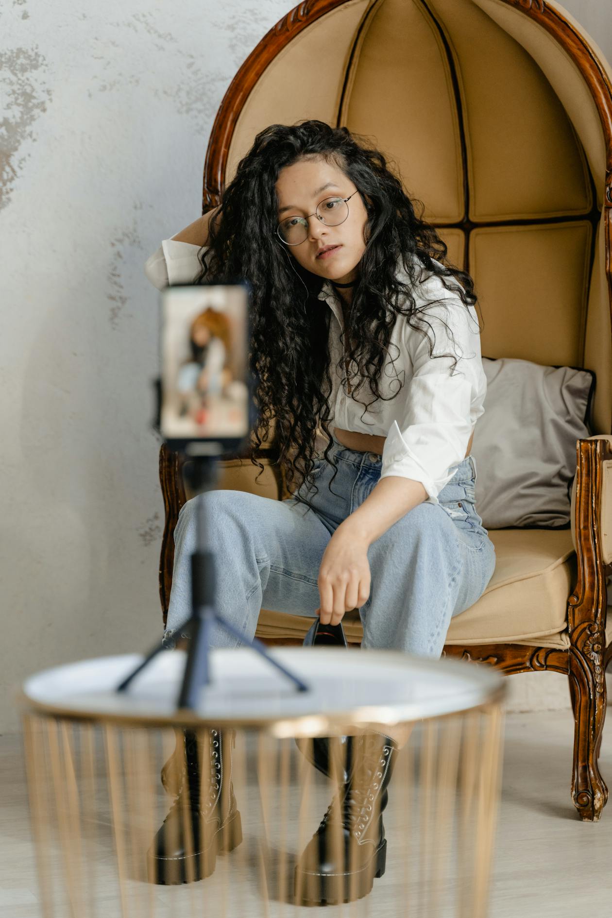 Woman filming herself seated indoors